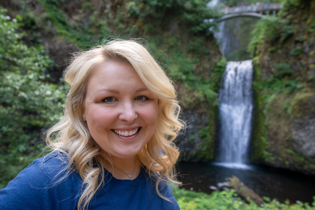 Happy blond woman (30-35 years old) poses at Multnomah Falls in Oregon